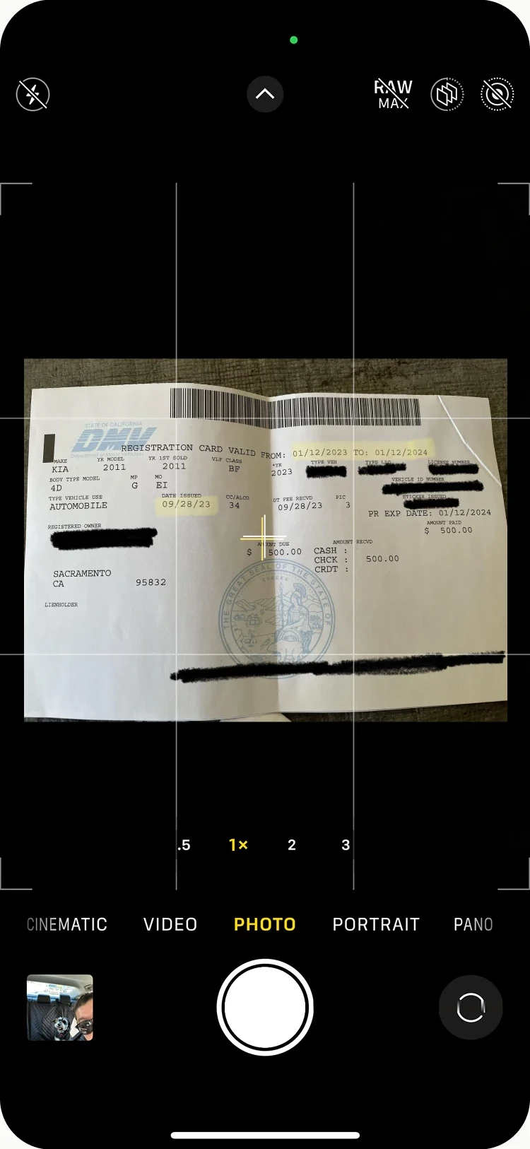 The camera open on a vehicle registration card.