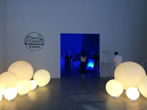 Glowing globe lights at the entrance of a La Prairie event