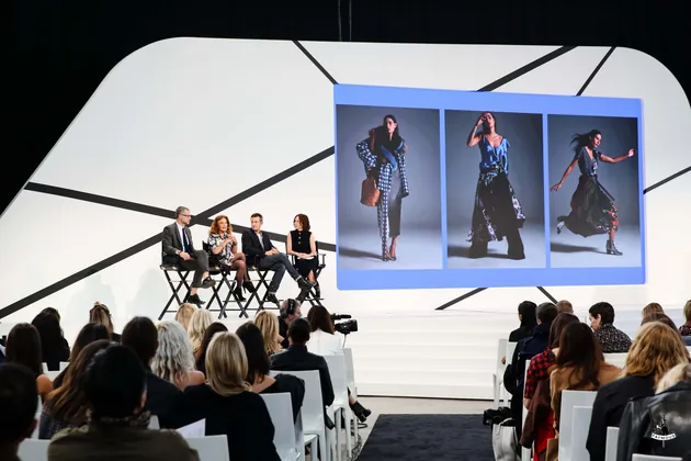 Panel on the Fashion Tech Forum stage with a runway photo screen