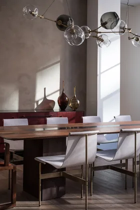 59 North Moore: a walnut dining table with sling chairs under a glass chandelier