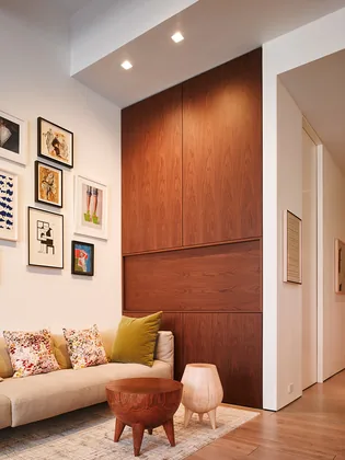 59 North Moore: a walnut wall of built-in cabinets beside a living room